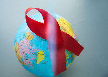 World AIDS day 1 December, close-up of world globe with red ribbonの写真素材