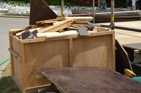 Wood construction waste lies in a wooden box on an open in the Park on a Sunny summer day.