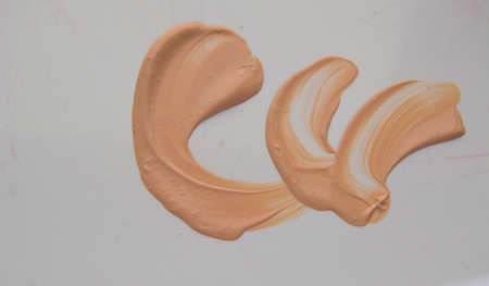 Liquid Foundation stain on white background. Surge of concealer highlighter.