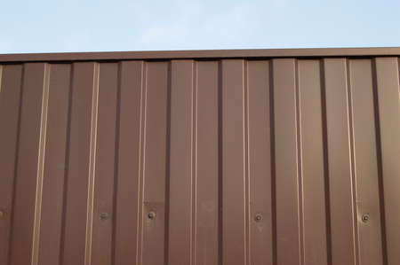 Modern aluminum fence of corrugated panel corrugated metal siding brown.の写真素材