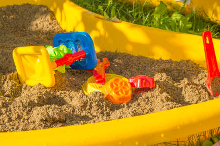 set of colored plastic toys on the sand, children's sandbox in summer Sunny day.の写真素材