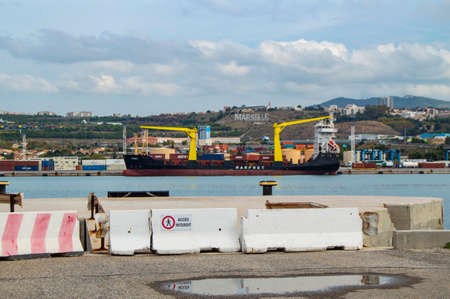 Sea view of Marseille's industrial harbour with cargo cranes and ships and its Hollywood inscription in the South of France.のeditorial素材