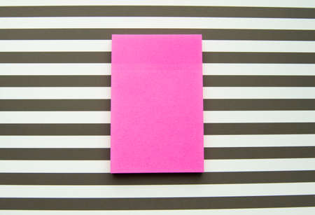 Red message sticker on black and white striped background, business objects.の写真素材