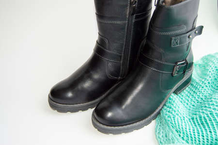 Fashionable and elegant womens winter leather shoes on white background, next green knitted jumper