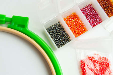 Flat lay Accessories for needlework and embroidery, hoops and beads on white background.
