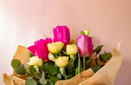 Flat lay creative layout is made with red and yellow flowers on pink background. The concept of spring.の写真素材