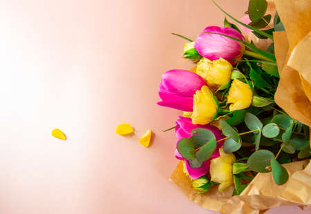 Flat lay creative layout is made with red and yellow flowers on pink background. The concept of spring.の写真素材