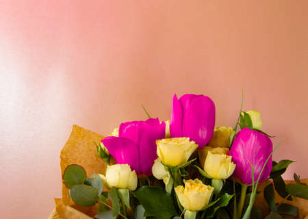 Flat lay creative layout is made with red and yellow flowers on pink background. The concept of spring.の写真素材