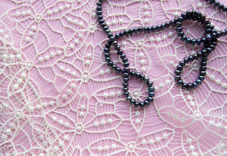 Lay Flat pink background and the gorgeous lace, glittering necklace of black pearls, and stylish...