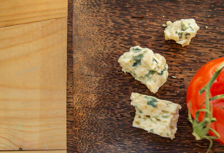 Wooden plate with tomato and cheese with mold. Flatley top viewの写真素材