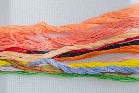 Bright colorful thread for embroidery thread on canvas. Handmade accessories on white background....