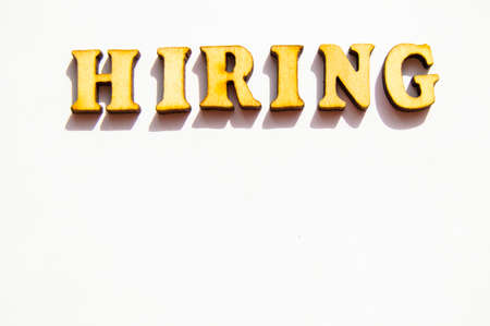The word hiring is written in gold letters, isolated on white background, copy space, mockup for designer.の写真素材