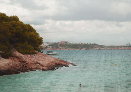 Sun's rays Shine through the clouds over the turquoise sea on the beach of Palma de Mallorca, a tranquil scene with a copy of the space.の写真素材