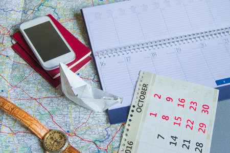 Diary and calendar with clock, passport, card, paper boat, travel concept with copy space.の写真素材