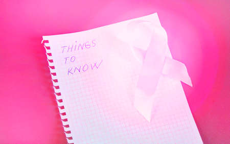 Things to know is written in Notepad with pink ribbon awareness breast cancer.の写真素材