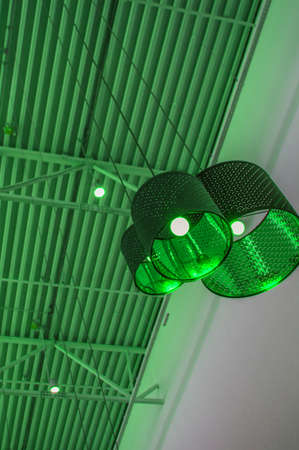 Ultra-modern style in green toned color decorative lamps and lampshades hang on long rope, industrial ceiling, interior design vertical shot.の写真素材