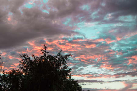 Colorful summer sunset after rain with dramatic blue and pink clouds, weather concept, seasonal...