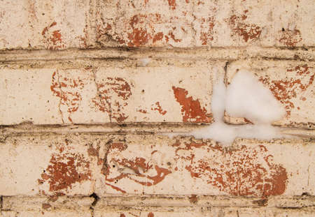 Cracked white plaster on old brickwork, close-up, grunge brick wall with space for text.の写真素材
