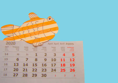 Funny fish drawn on the calendar, close-up. April fools ' day concept isolated on a blue backgroundの写真素材