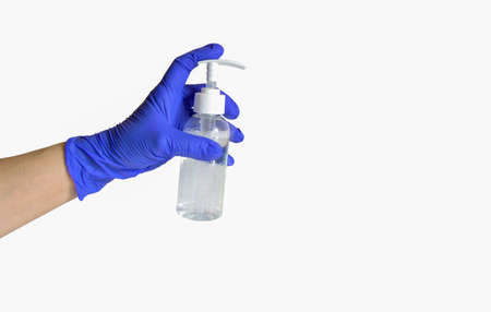 A hand in a blue rubber protective glove held a white bottle of sanitary spray. Isolated on a white...