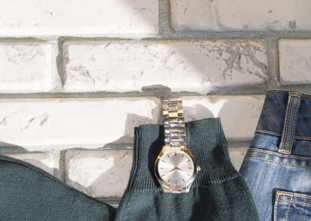 A set of mens clothing and accessories on a gray brick wall background. Casual dark blue and green clothingの写真素材