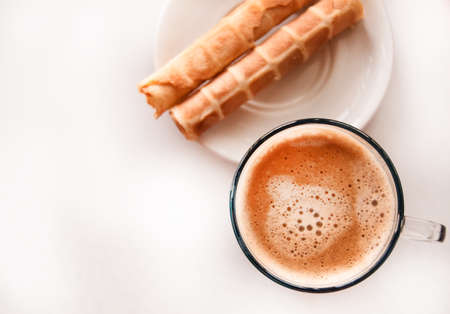 Clear blue glass with frothy hot espresso coffee and crispy waffles, top view, delicious Breakfast