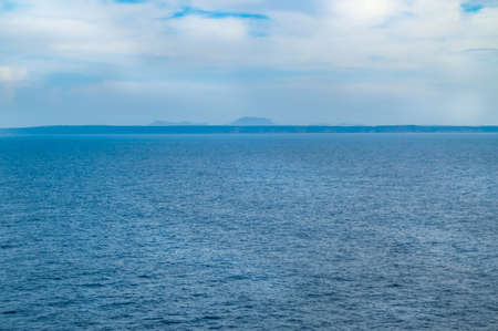 Amazing clouds over the sea in the pre-dawn hour, the horizon line with mountains, the Mediterranean sea, the coastline of Italy.の写真素材