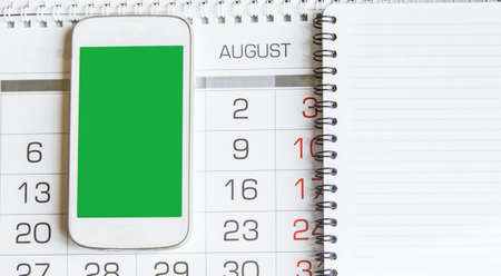 The business workplace. the view from the top on the calendar August, notebook and mobile phone with...
