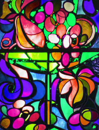Abstract stained glass background of multicolored glass with floral and fruit ornaments, vertical frame.の写真素材