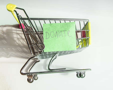 A piggy bank in a shopping basket on a white background and a paper template with the inscription...