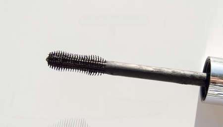 Close-up of a part of a golden tube of lipstick on a white background.の写真素材