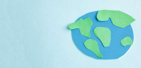 Cute children's paper applique -a model of the Earth and a young sprout on a blue background. Creative concept Earth Day, Earth Hour, copy space for text.の写真素材