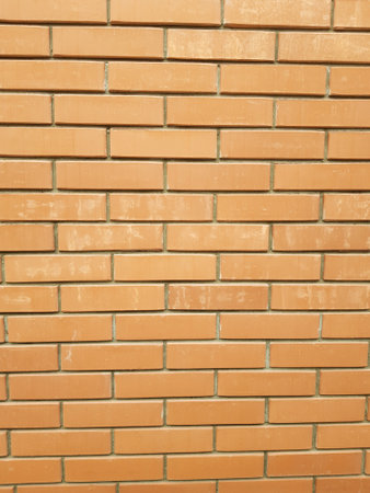 The modern texture of an orange brick wall is the background material of industrial construction.