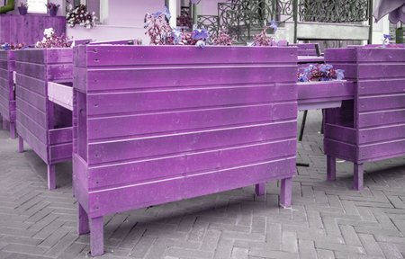 Evening time with purple tinting, outdoor outdoor cafe with wooden furniture, close-up.の写真素材