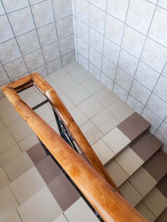 Top view of the staircase of a modern staircase with ceramic tile steps and wooden railings, vertical.の写真素材