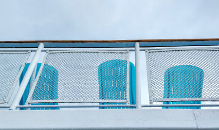 A view from below of the railing and the backs of the deck chairs on the sun deck of the passenger liner.の写真素材