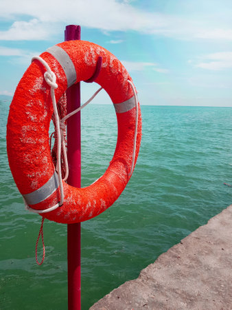 Lifebuoy on the background of the azure sea, sea pier in the sea, close-up, vertical.の写真素材