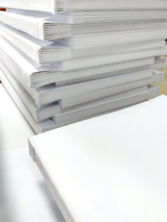 Close-up, a stack of glued book blocks prepared for binding in a printing house, vertical.