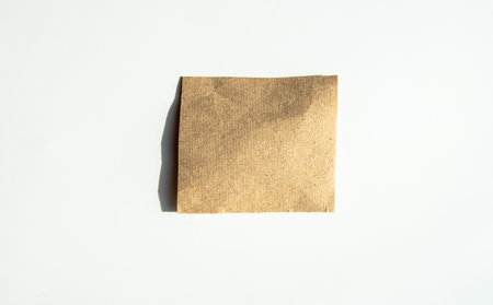 Square kraft sticker, sheet of brown note paper, isolated on a white background.