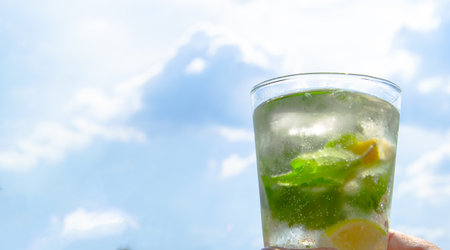 Cold tropical mojito cocktail on the background of blue sky, banner.の写真素材