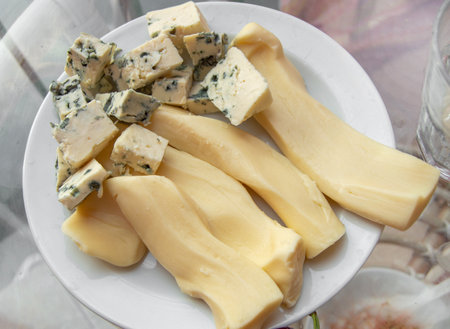 Blue cheese, diced, on a plate, top view.の写真素材