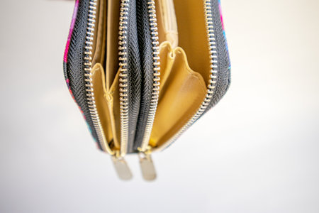 Fashionable outdoor women's empty wallet with gold zippers, top view, on white background.