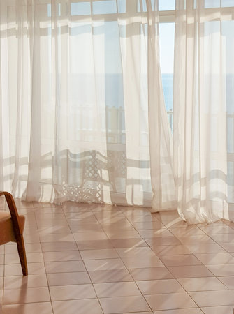 Soft sunlight through sheer white curtains with sea view. premium atmosphere, website and banner...