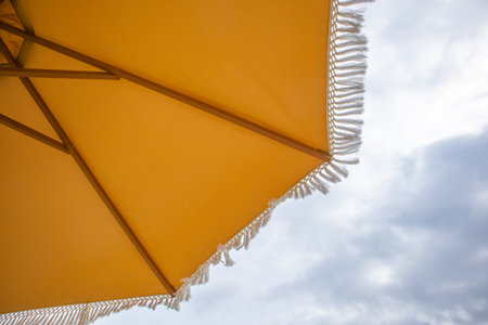Close up umbrella against sky. Summer vacation and sun protection concept. Minimal background with copy space. Horizontal image. No people. sustainable travel, eco friendly, sun safety, UV protection, dopamine colors, summer sale, mindful travelの写真素材