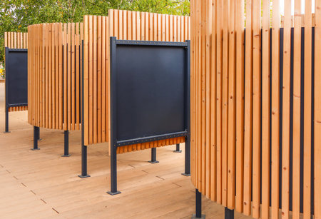 Outdoor beach changing cabin with curved wooden slats and dark panels modern public space...