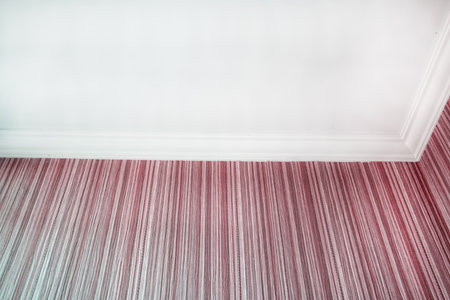 White ceiling and pink striped wallpaper with crown molding close upの写真素材