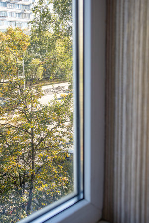 Window view to city street and trees vertical frame