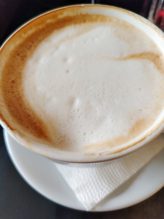 Cappuccino with rich milk foam in a ceramic cup top view Ideal for coffee shop menus branding and specialty coffee marketing Works for posters app covers and social media contentの写真素材