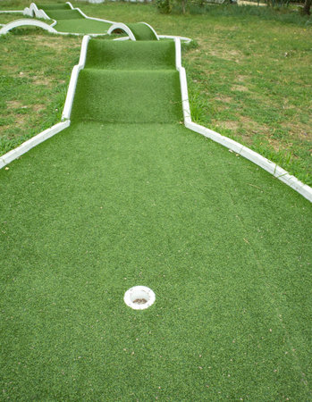 Vertical mini golf lane with hole artificial turf and ramps Ideal for family fun advertising parks and attractions suitable for posters banners and social media contentの写真素材