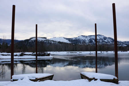 Snow covered dock on a riverの写真素材